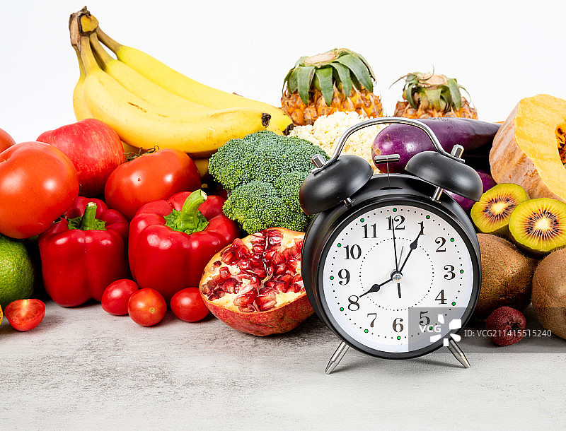 丰富多种的新鲜蔬菜水果和一个闹钟图片素材