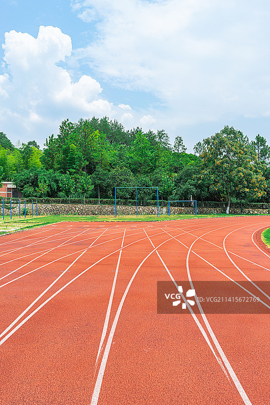 中国学校操场拍摄主题，红色塑胶跑道，天空的云，绿色的操场，看台和建筑外部，户外无人图像摄影图片素材