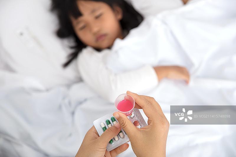 手里拿着儿童药给孩子吃图片素材