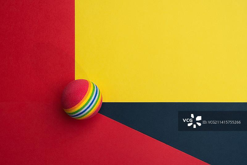 放在黑黄红背景中的彩色小球静物图图片素材