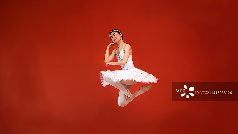 年轻女子在红色背景下跳舞，马来西亚吉隆坡图片素材