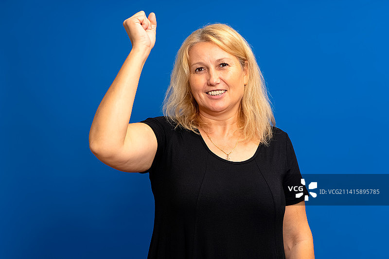 兴奋的40多岁白人妇女举手庆祝图片素材