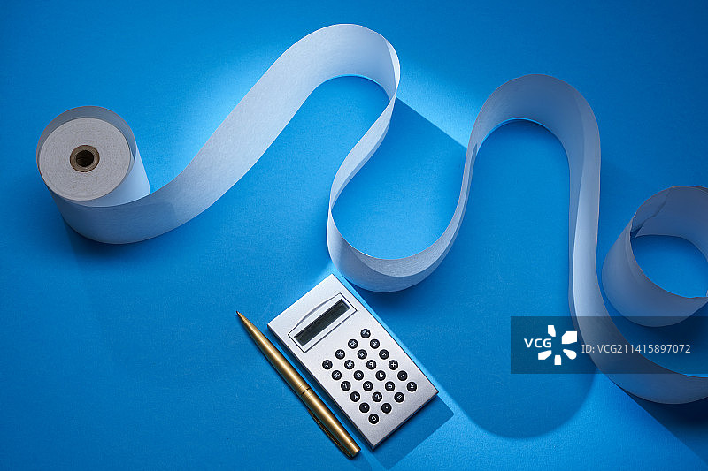 蓝色背景下的加法机纸带和银色计算器，马来西亚图片素材