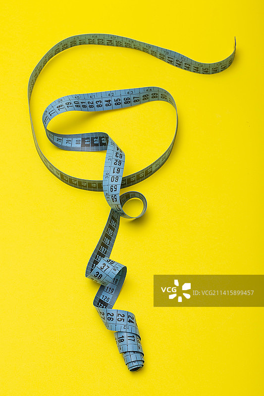 黄色背景上的裁缝卷尺图片素材