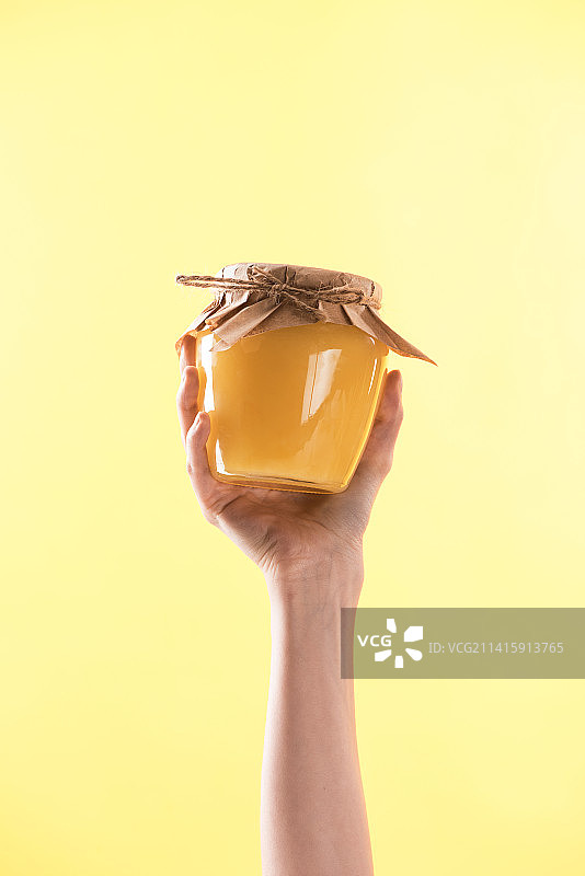 手持容器，黄色背景图片素材