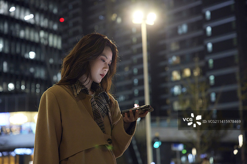 商务女性下班天桥上玩手机图片素材