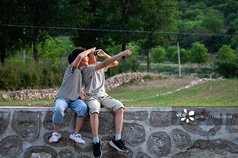 兄妹俩在用望远镜眺望远处图片素材