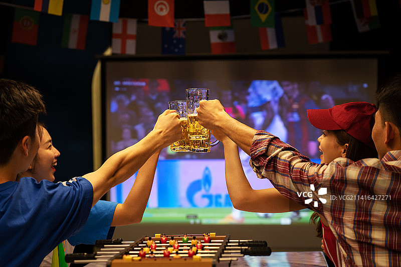 年轻朋友喝着啤酒看足球比赛图片素材