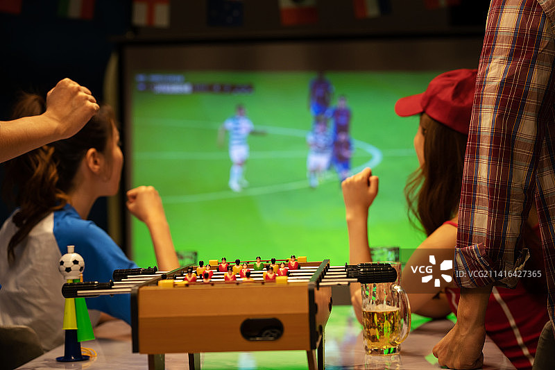 年轻朋友一起从投影屏幕上看足球比赛图片素材