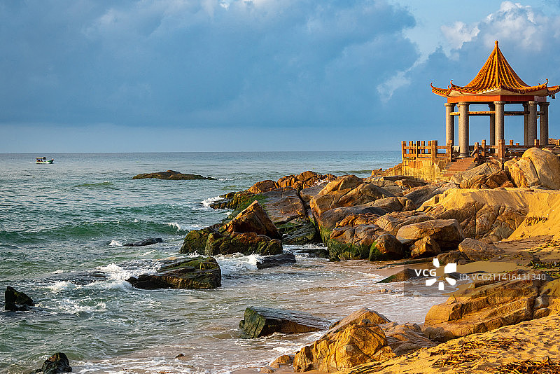 陵水富力湾附近，椰子岛位于陵水河出海口，日出时分温暖的阳光照射岸边黄色八角亭，守护着过往船只图片素材