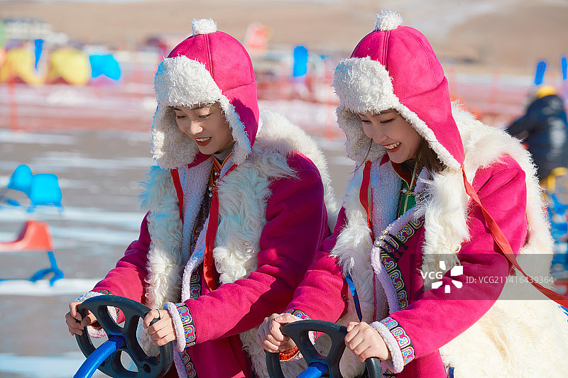 冬天在冻结湖面玩嬉戏滑冰的闺蜜少女图片素材