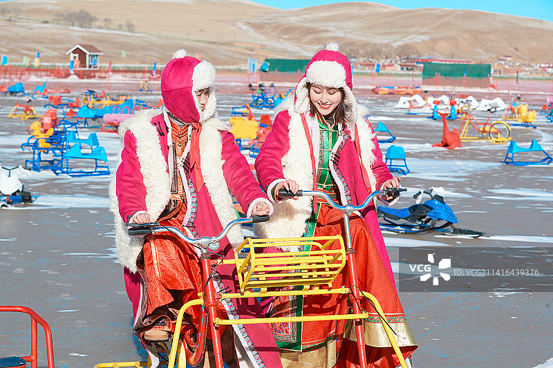 冬天在冻结湖面玩嬉戏滑冰的闺蜜少女图片素材