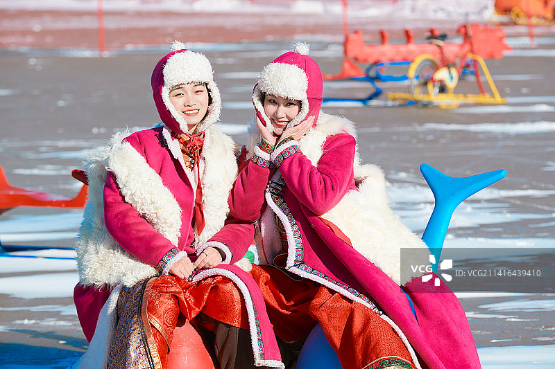 冬天在冻结湖面玩嬉戏滑冰的闺蜜少女图片素材
