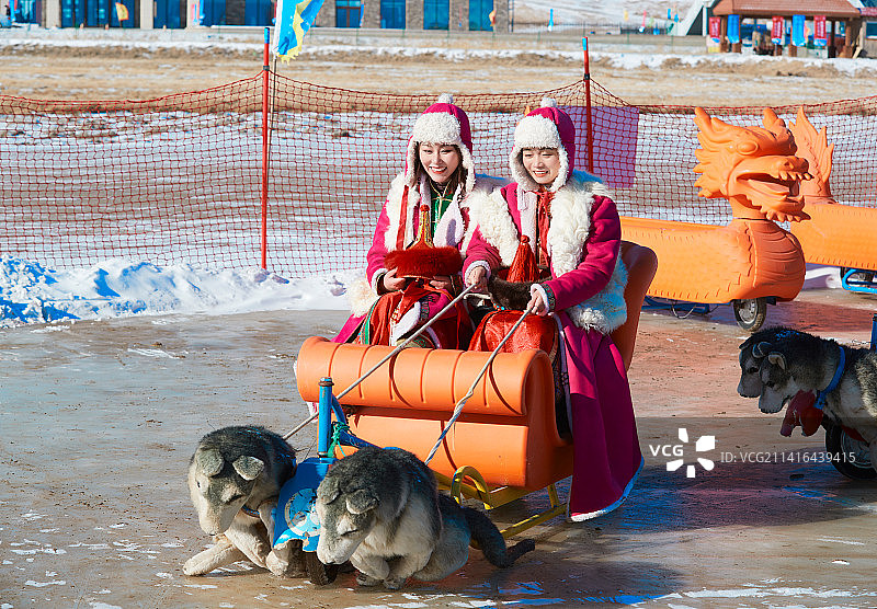 冬天在冻结湖面玩嬉戏滑冰的闺蜜少女图片素材