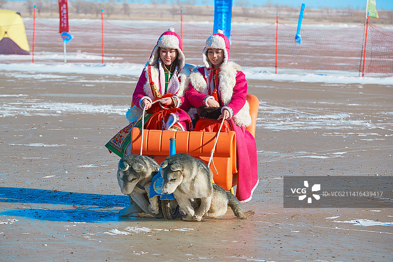 冬天在冻结湖面玩嬉戏滑冰的闺蜜少女图片素材