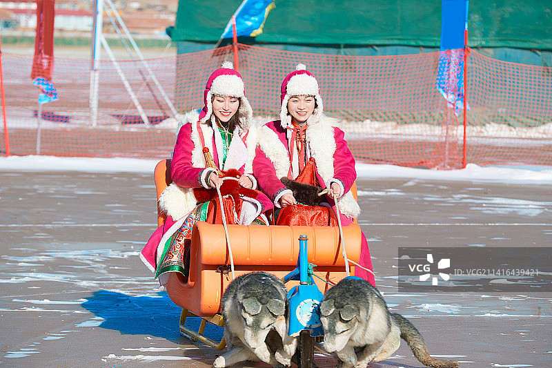 冬天在冻结湖面玩嬉戏滑冰的闺蜜少女图片素材