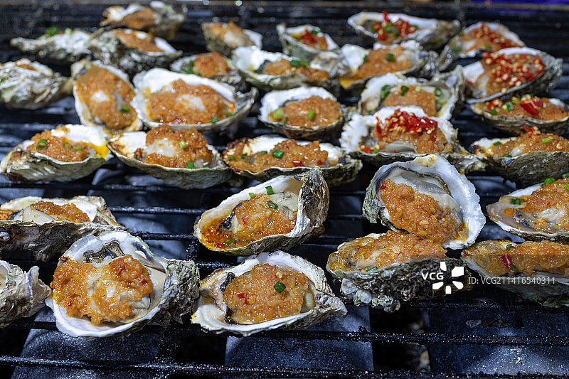 烧烤架上的一堆烤生蚝特写镜头图片素材