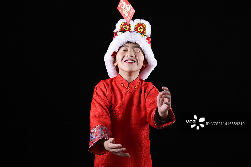 带虎头帽的中国小男孩和新年红包图片素材