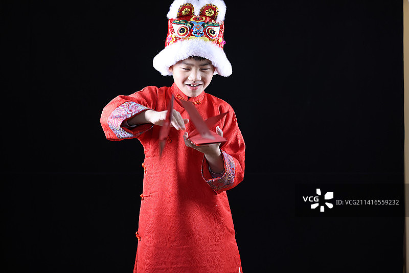 带虎头帽的中国小男孩和新年红包图片素材