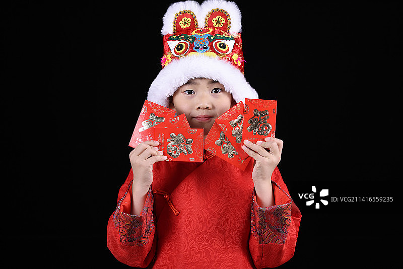 带虎头帽的中国小男孩和新年红包图片素材