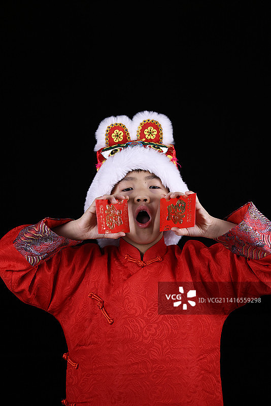 带虎头帽的中国小男孩和新年红包图片素材