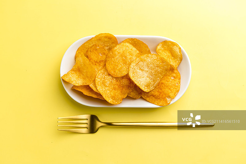 一盘炸薯片摆放在桌面上特写图片素材