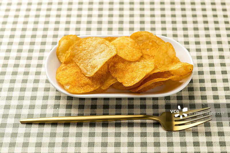一盘炸薯片摆放在桌面上特写图片素材