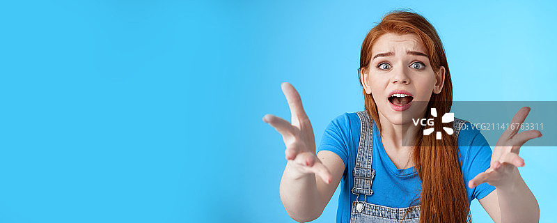 不开心的红发女孩特写，举起双手图片素材