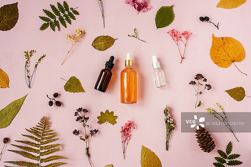 粉色花卉背景上的面部精华液图片素材