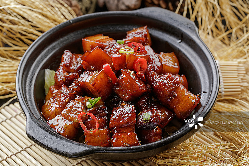 寿司帘上的黑色砂锅装的毛氏红烧肉图片素材