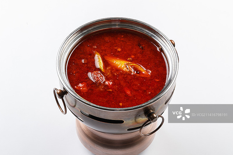 白色背景上的小火锅装的香辣红油锅底图片素材