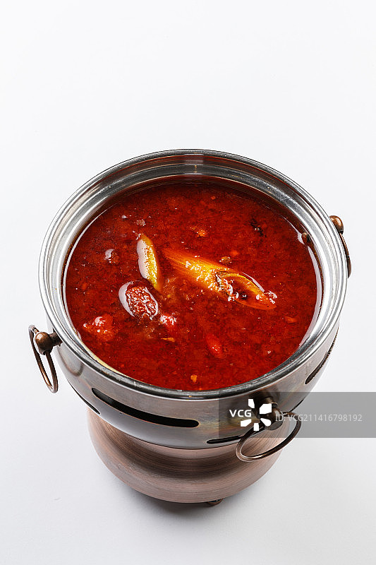 白色背景上的小火锅装的香辣红油锅底图片素材