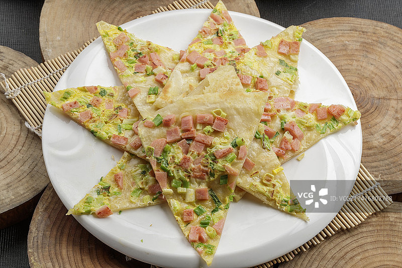 白色瓷盘装的蔬菜熏肉烙饼图片素材