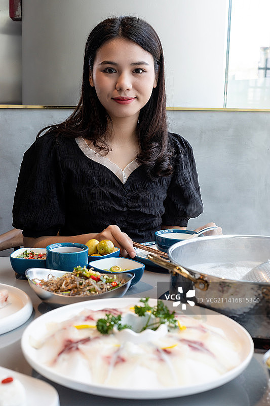 中国年轻女子在吃中山脆肉鲩火锅图片素材