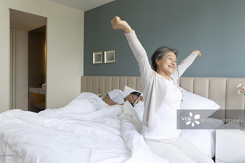 老年女子在卧室起床伸懒腰图片素材