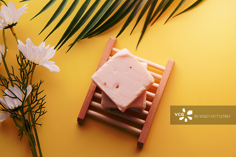 黄色背景下的自制天然手工皂和花朵图片素材