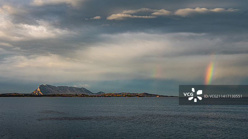 意大利撒丁岛圣特奥多罗海岸线和岛屿上空的日落彩虹图片素材