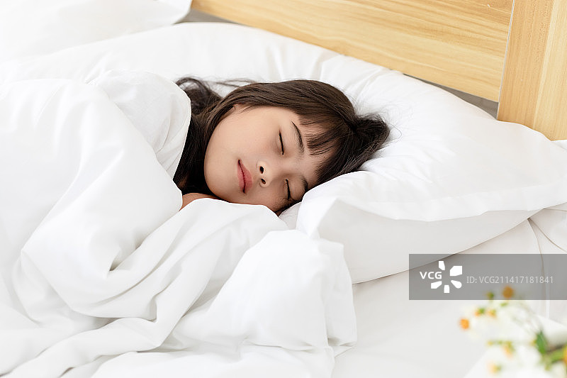 一个中国小女孩在床上睡觉图片素材