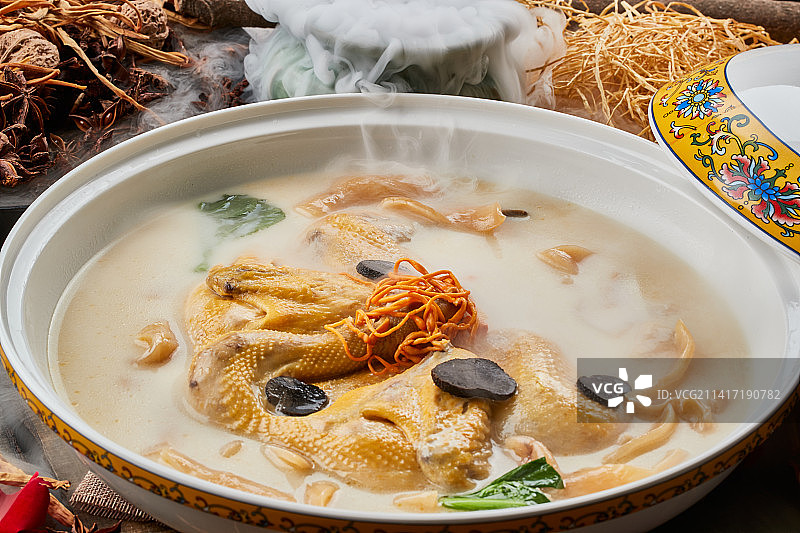 陈旧木板上的圆瓷汤盆装的花胶葛根炖柴鸡汤图片素材