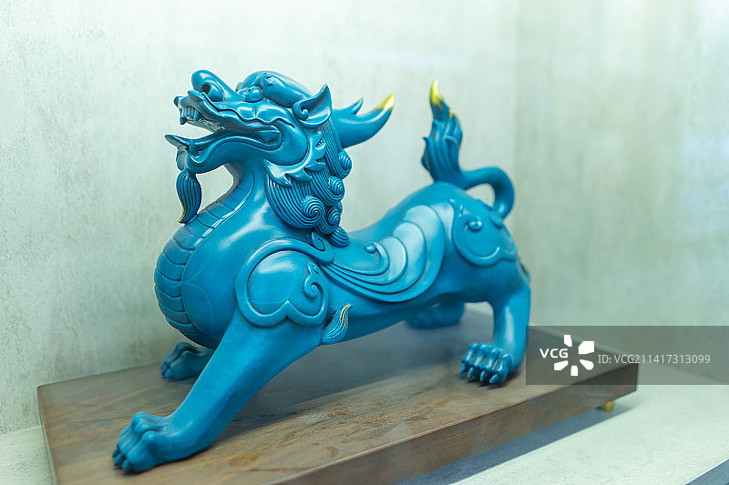 中国传统文化艺术拍摄主题，博物馆架子上摆设着动物主题的手工艺品蓝色的麒麟龙雕塑，室内无人图像摄影图片素材