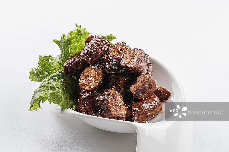 勺型白瓷盘装的麻辣鸭脖图片素材