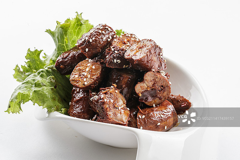 勺型白瓷盘装的麻辣鸭脖图片素材