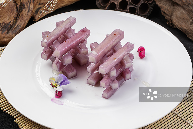 圆形瓷盘装的蓝莓长山药摆放在寿司帘上图片素材