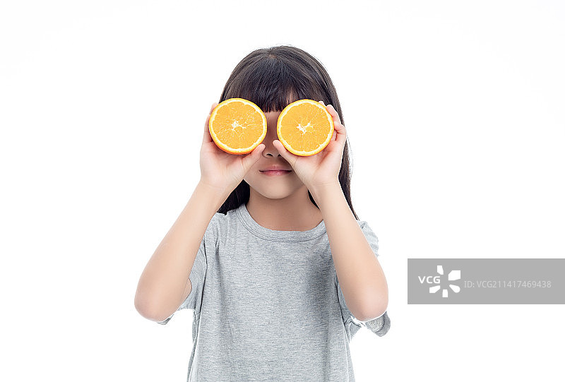 白色背景中一个小女孩在吃橙子图片素材