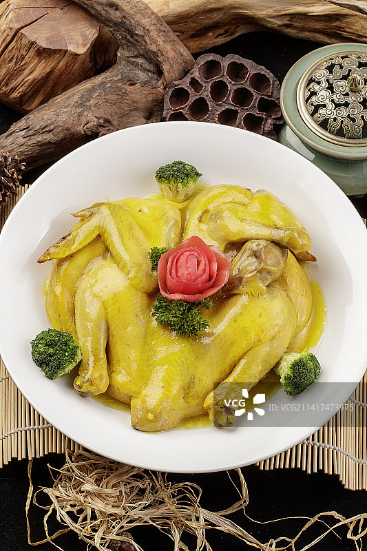 圆形瓷盘装的清蒸三黄鸡摆放在寿司帘上图片素材