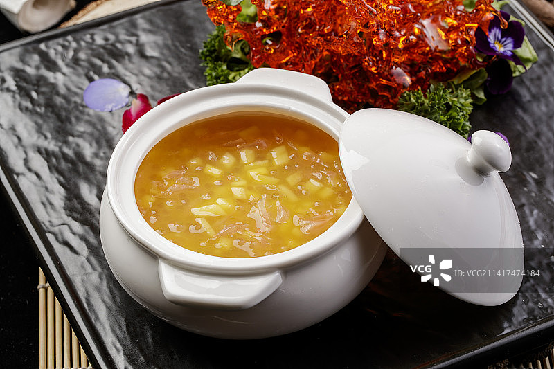 白色汤盅装的木瓜银耳羹摆放在黑色石盘上图片素材