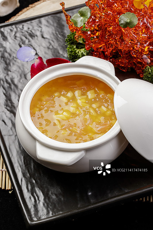 白色汤盅装的木瓜银耳羹摆放在黑色石盘上图片素材