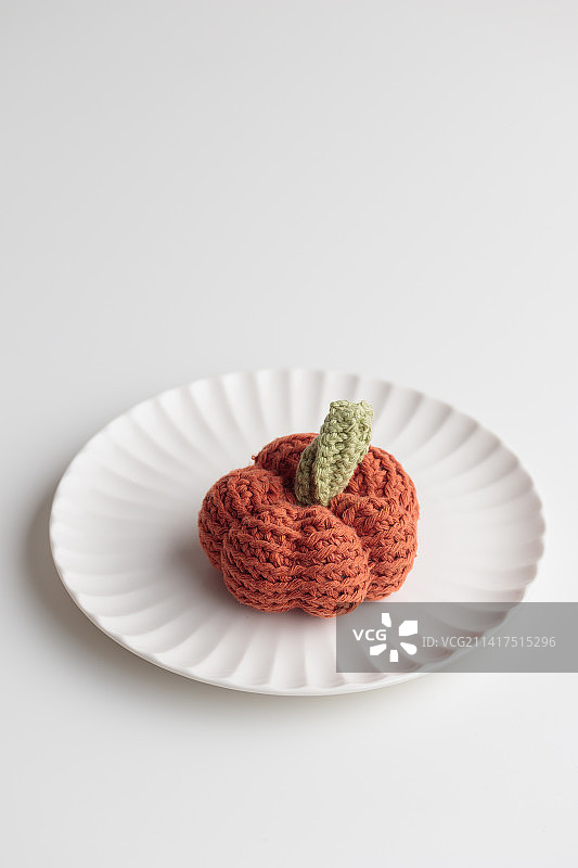 白色桌子上的钩针编织南瓜（芬兰）图片素材