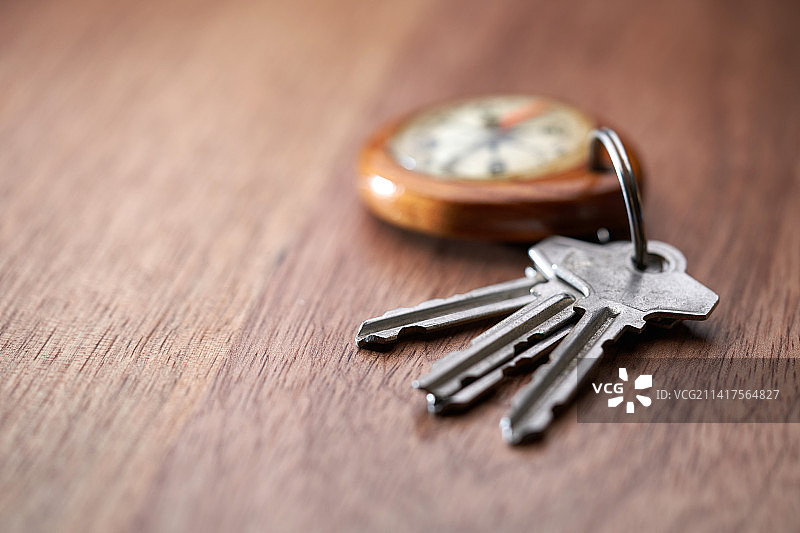 房屋钥匙和指南针钥匙圈，背景为木纹，马来西亚图片素材