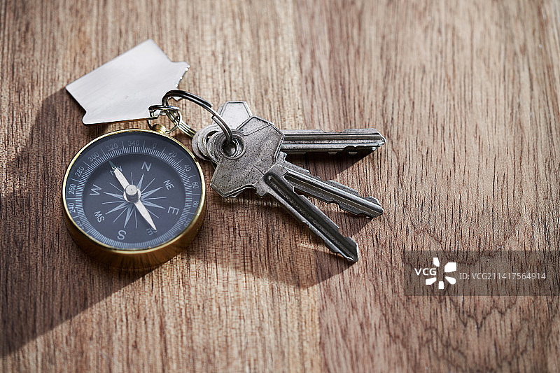 房屋钥匙和指南针钥匙圈，背景为木纹，马来西亚图片素材